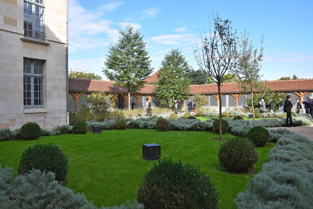 Kering: Lawn with clipped box balls and trees in an enclosed courtyard garden