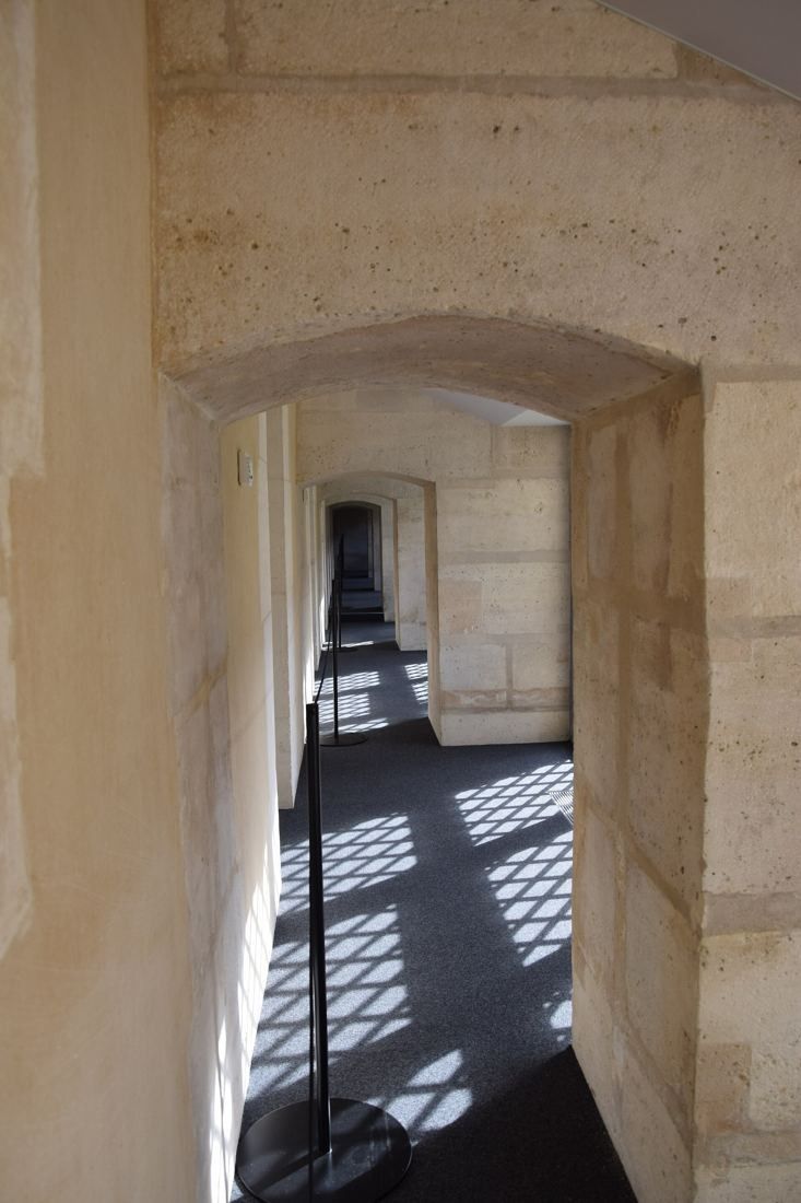 Kering: Narrow stone passage with a lattice shadow on the floor