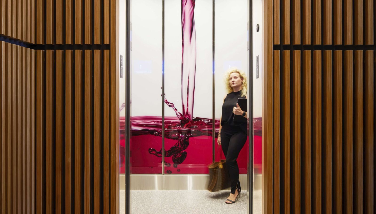 Keurig Dr Pepper: A woman walking past a wall printed with a red drink splashing into a glass