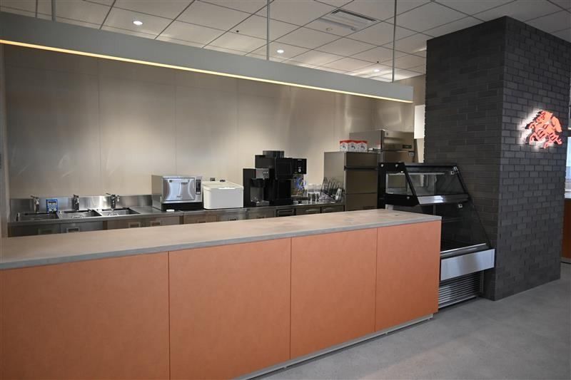Kirin Holdings: Café service counter with coffee machines and a dark brick column