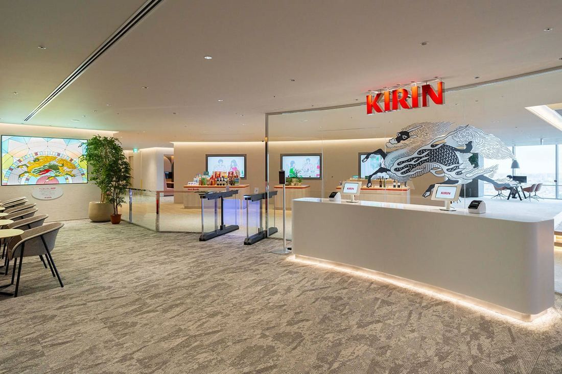 Kirin Holdings: Reception desk under a large KIRIN sign with a mythical kirin artwork behind it