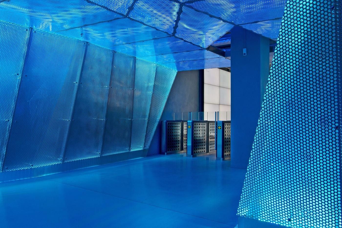 Klarna: Blue floor and angled perforated blue wall panels by entrance gates