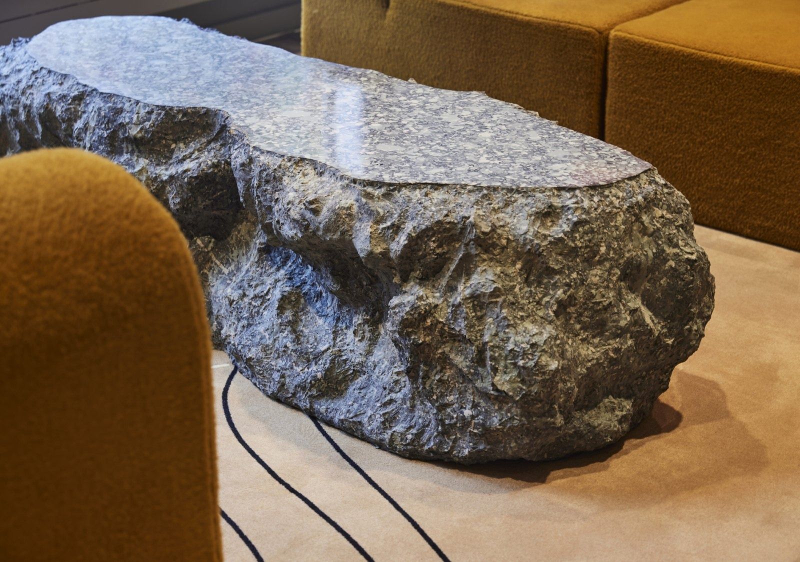 Klarna: Rough granite stone used as a table beside an ochre sofa