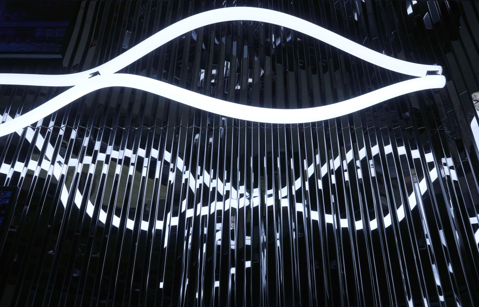 Klarna: Wavy white light lines over a dark slatted ceiling