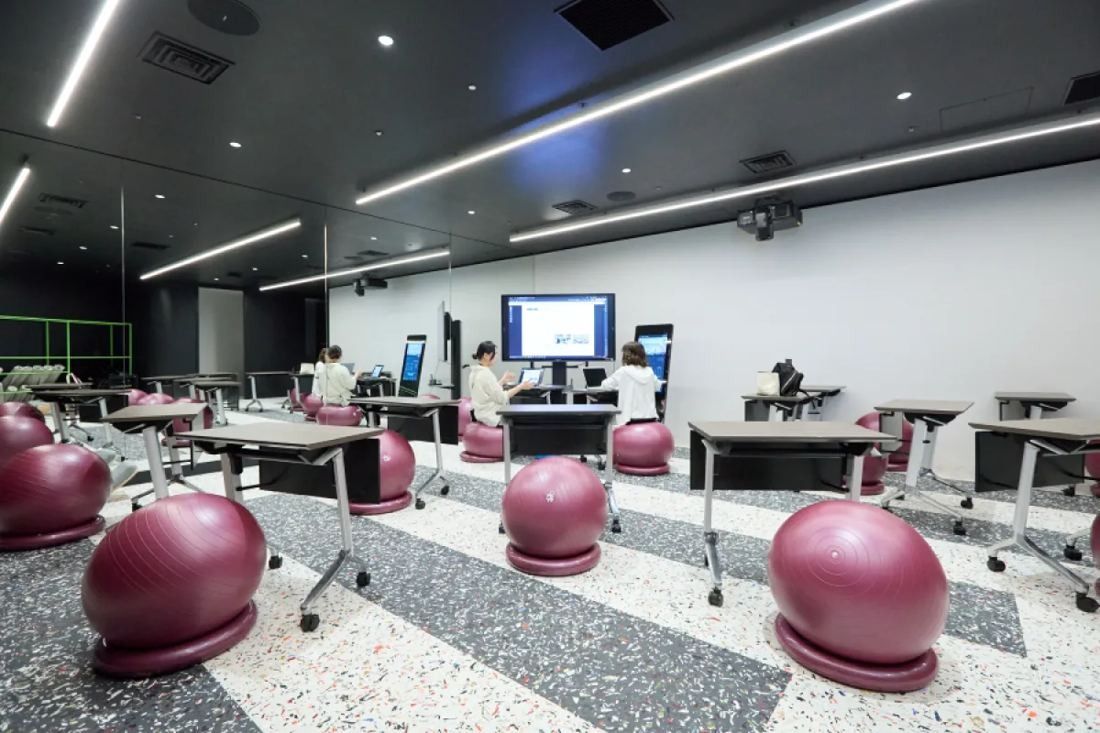 KOKUYO: Room with a terrazzo floor, purple exercise balls and screens on stands