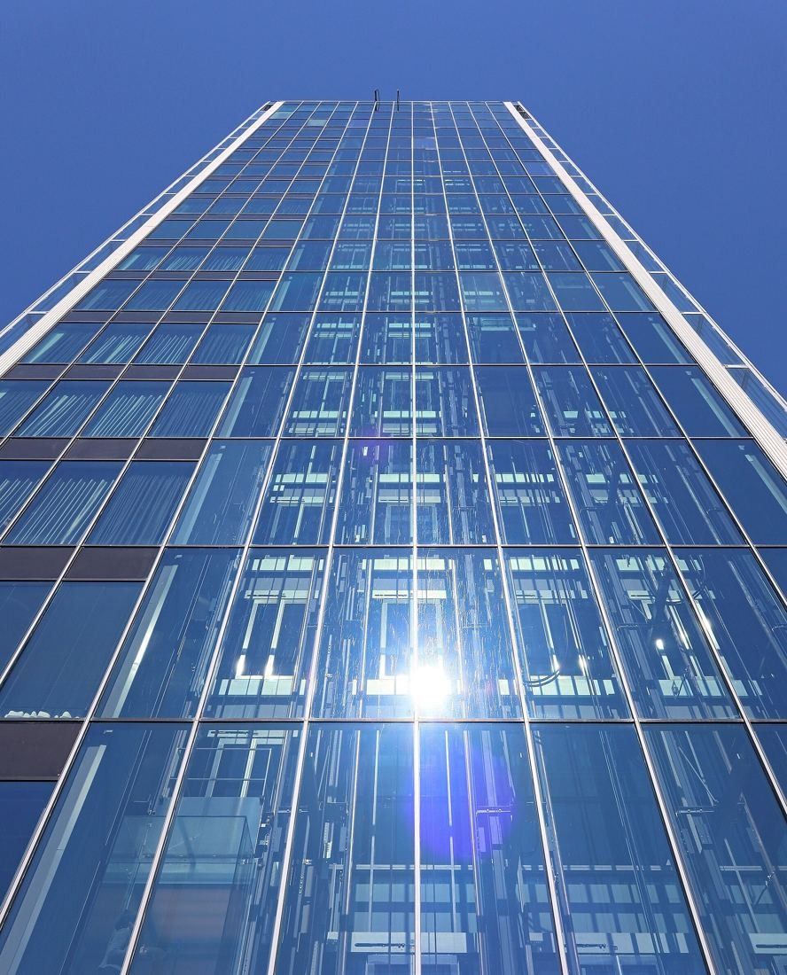 KONE: Close view up a glazed facade with the sun reflecting in the glass