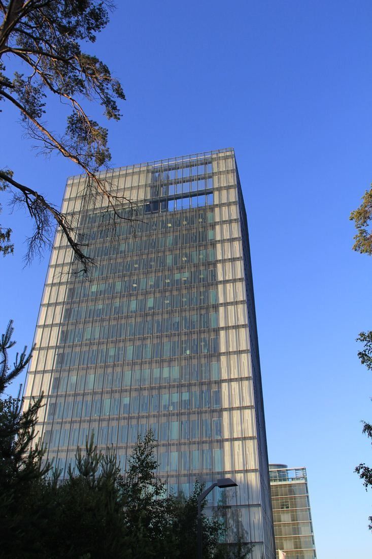 KONE: Glass tower seen through trees against a blue sky
