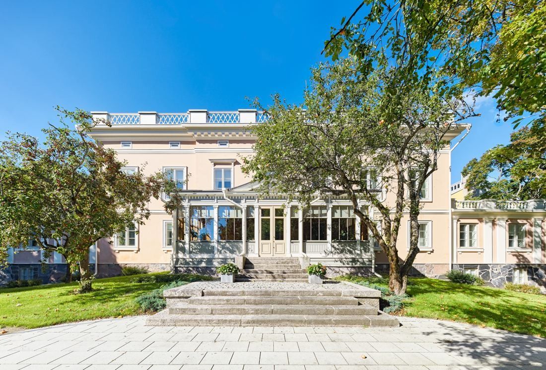 KONE: Pale pink neoclassical manor house with stone steps and a lawn framed by trees