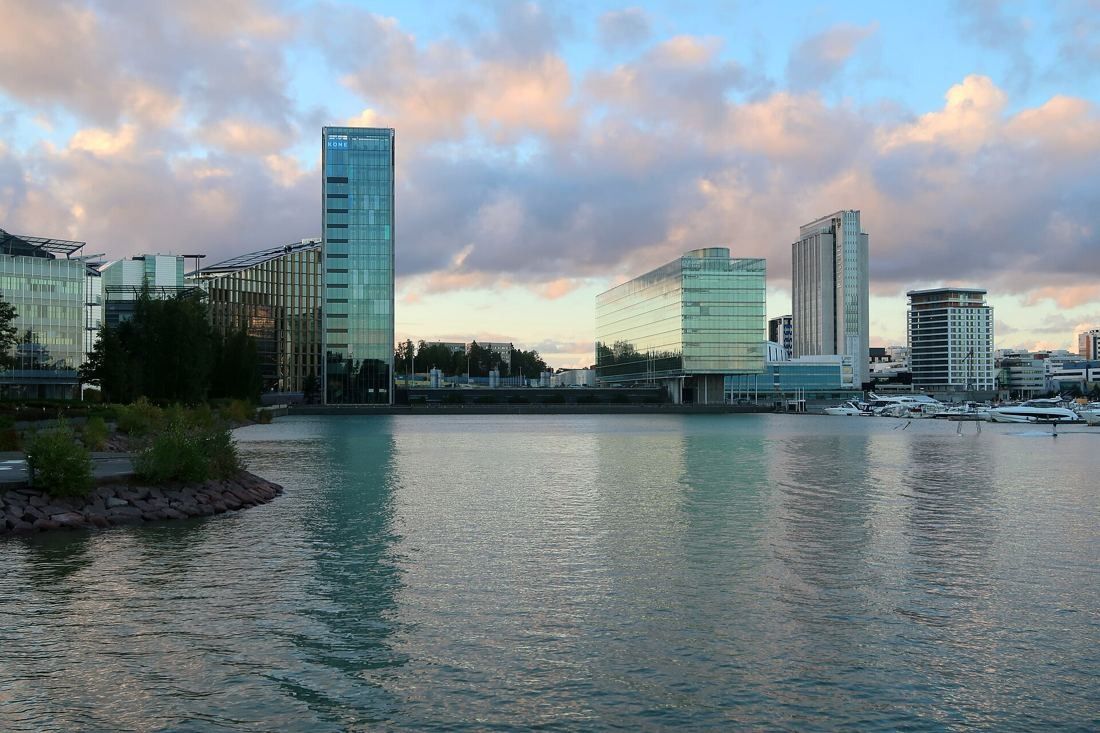 KONE: Waterfront business district with a slim glass tower among office buildings