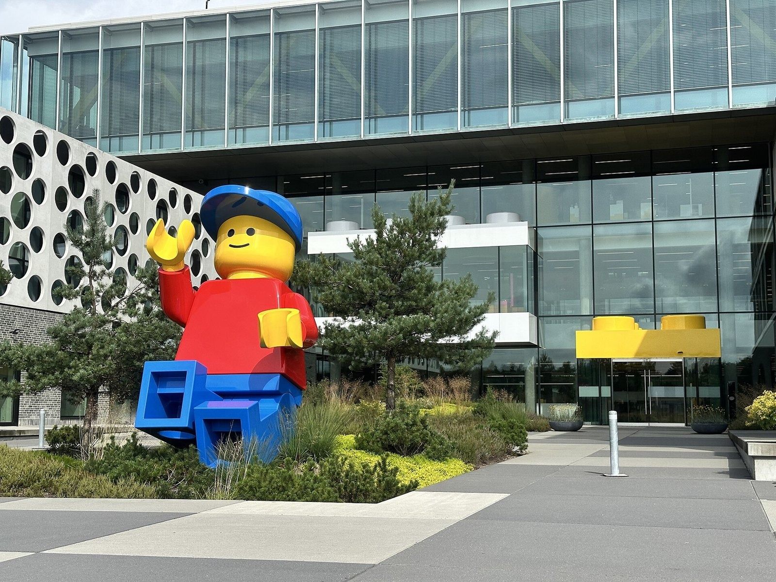 The LEGO Group: Giant minifigure in front of the glass entrance
