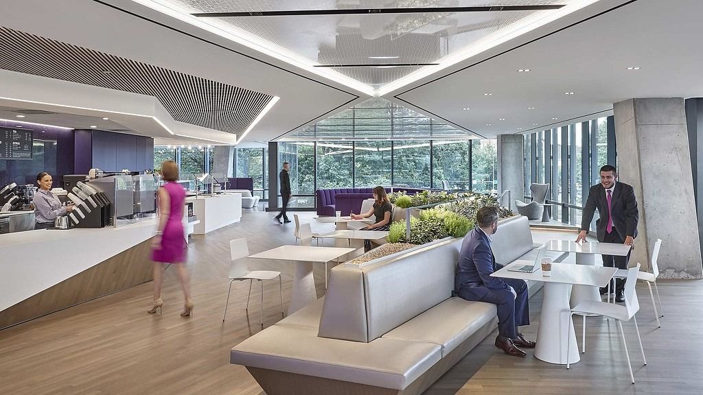 Leidos: A bright café space with long tables, planters and big windows