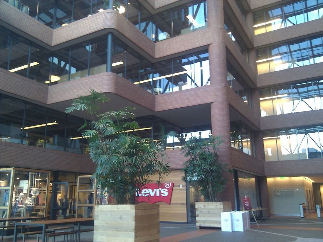 Levi Strauss & Co.: Atrium with brick balconies, large potted plants and glass storefronts on the ground floor