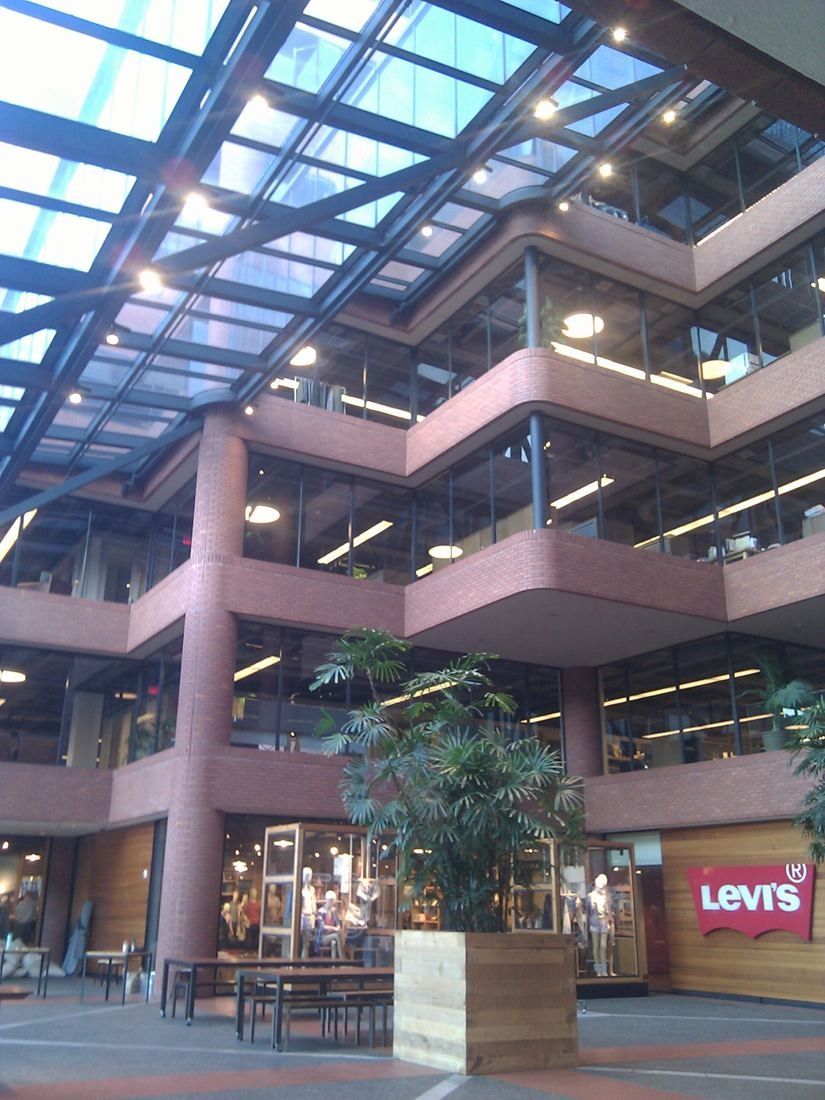 Levi Strauss & Co.: Brick atrium with stepped balconies, a glass roof and potted trees on the ground floor