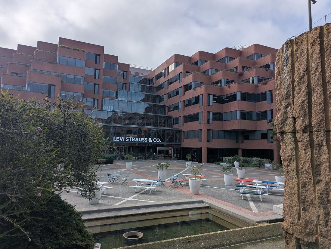 Levi Strauss & Co.: Brick office building seen past a granite fountain block and plaza seating