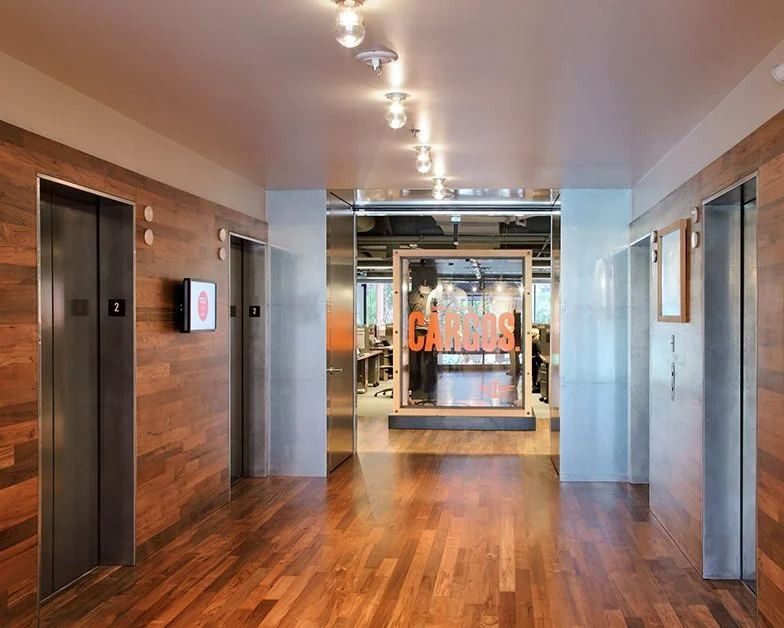 Levi Strauss & Co.: Elevator lobby with wood floor and walls leading to a glass display