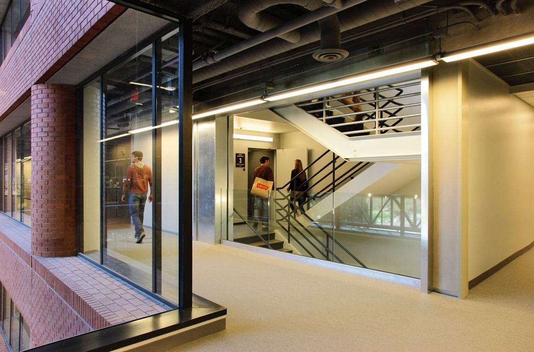 Levi Strauss & Co.: Glass-walled stairwell next to the brick facade with people walking on the stairs