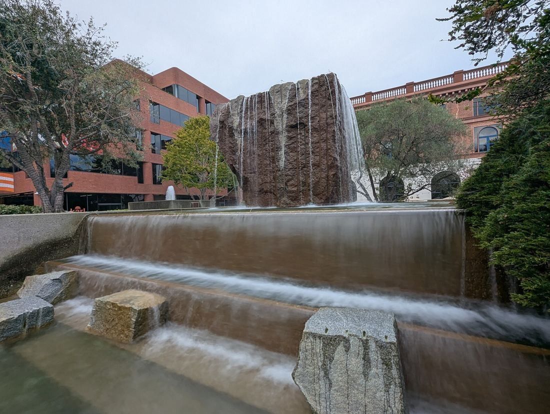 Levi Strauss & Co.: Granite fountain with water falling into a shallow pool, brick buildings behind