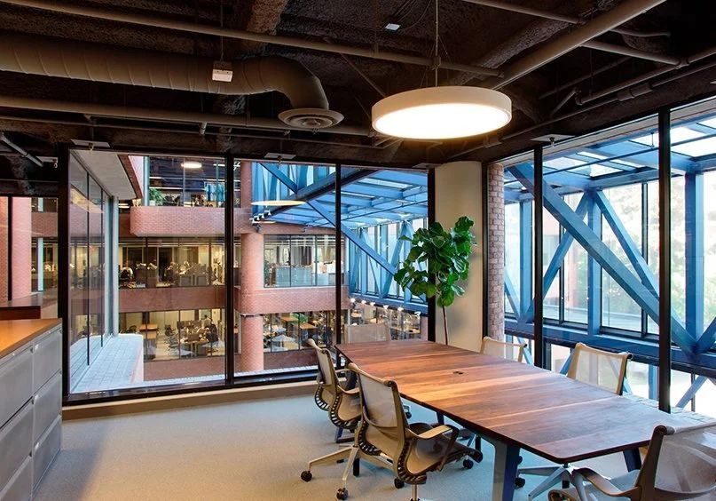 Levi Strauss & Co.: Meeting room with a long wood table and glass walls looking into the atrium