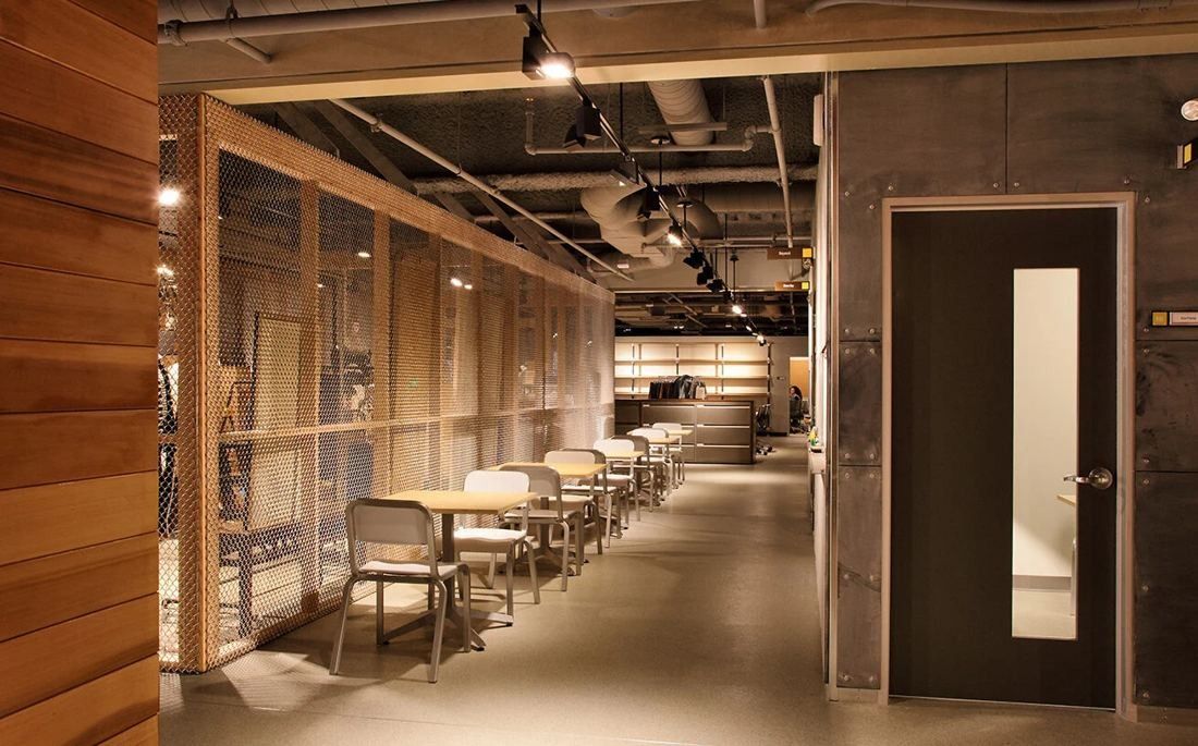 Levi Strauss & Co.: Narrow room with a row of small tables along a wood-slat wall