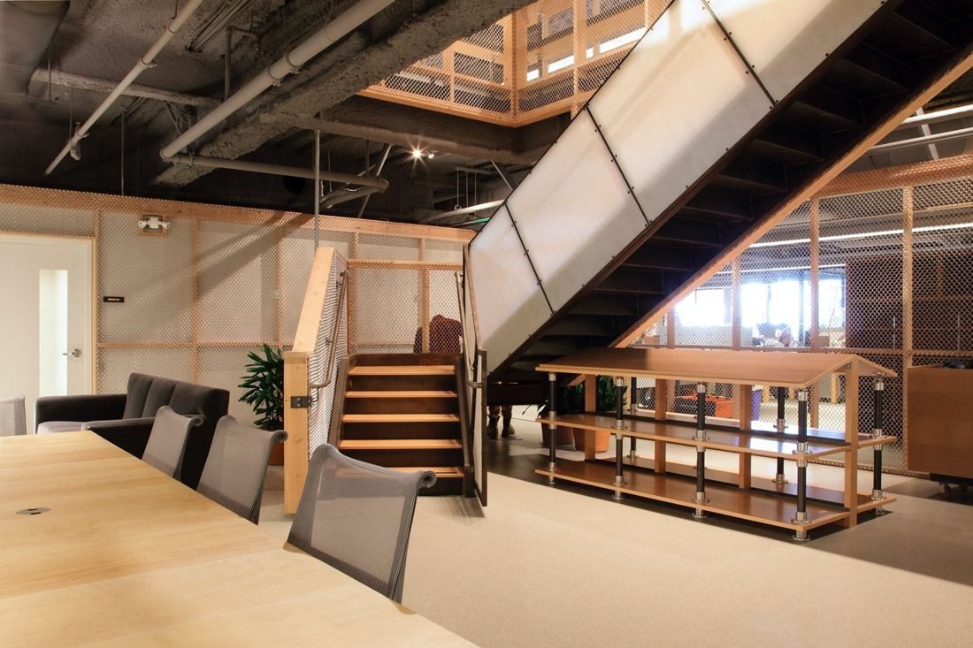 Levi Strauss & Co.: Office floor with a wooden stair rising to the next level beside a long table