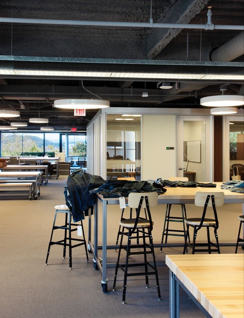 Levi Strauss & Co.: Work area with tall stools around tables and a row of glass meeting rooms