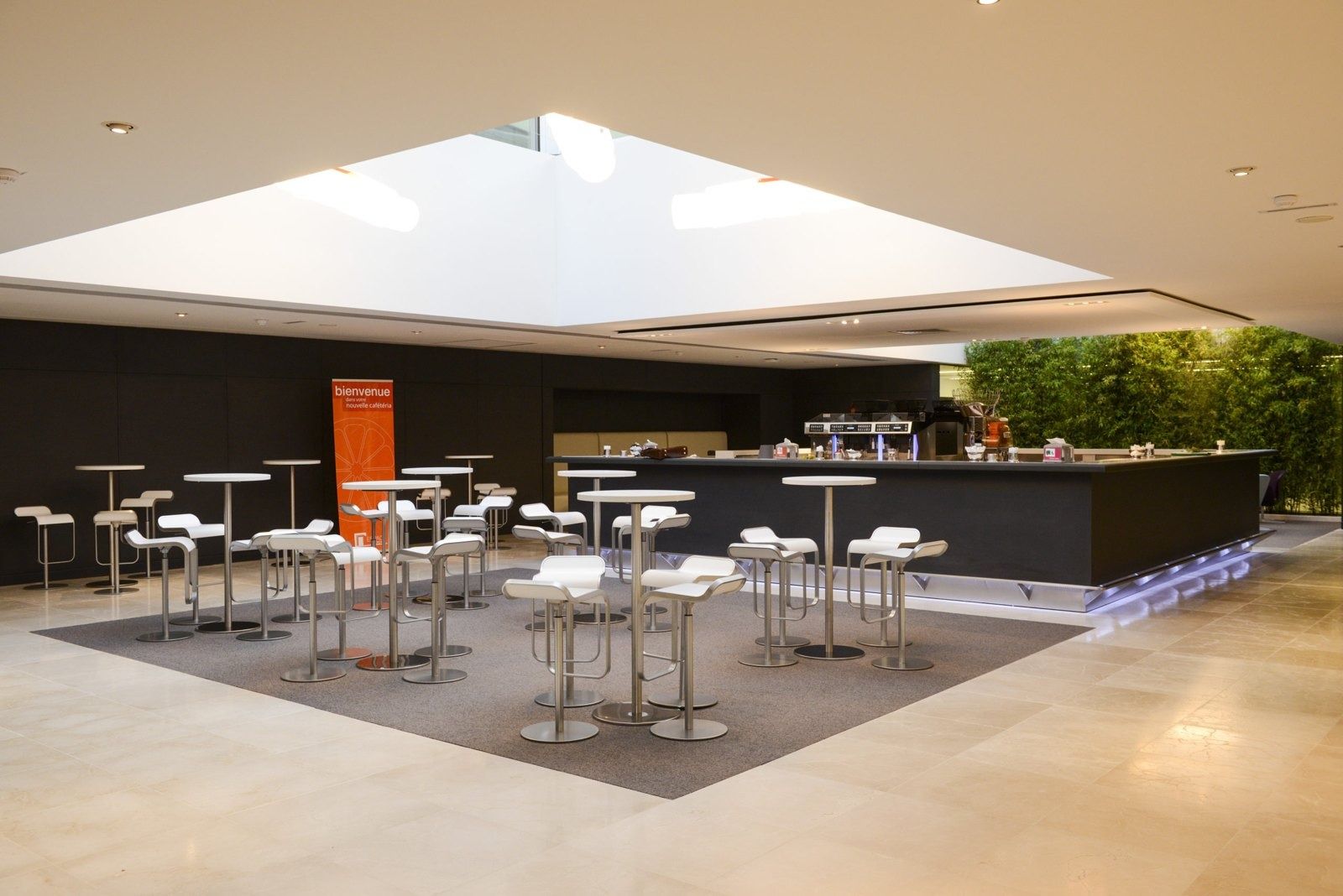 L'Oréal: A cafeteria under a skylight with standing tables
