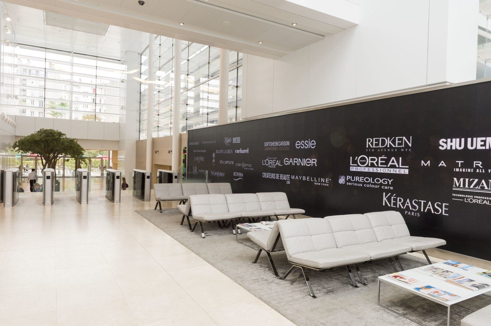 L'Oréal: A lobby with white sofas and brand names on a black wall