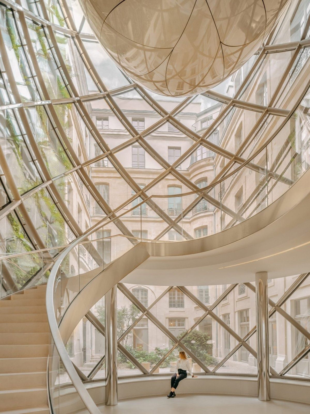 L'Oréal: White spiral stairs rising through a lattice of glass and steel