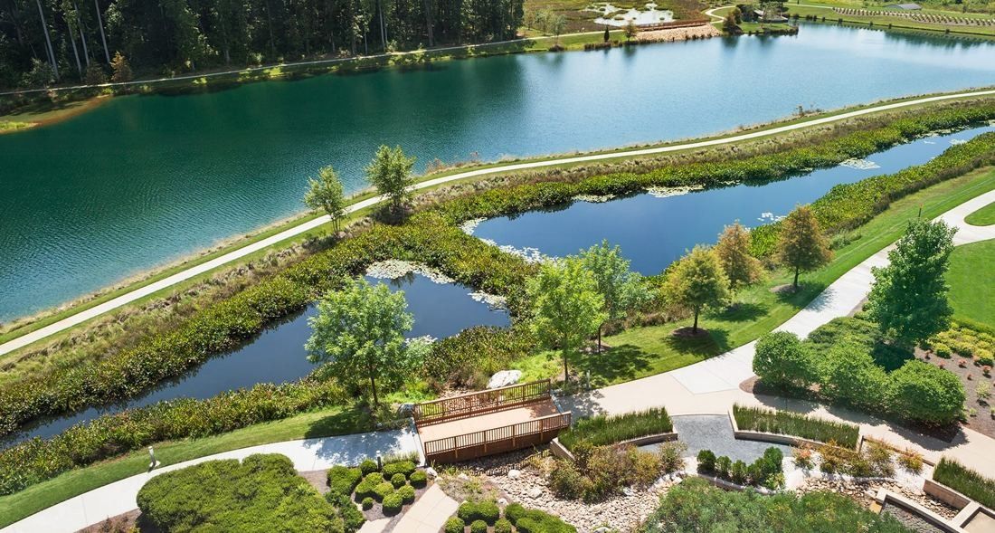 Lowe's: Aerial view of a lake with planted islands, walking paths and a small bridge