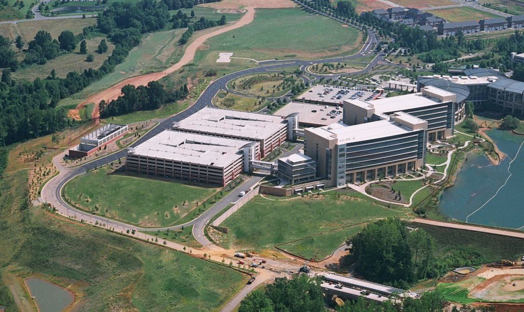 Lowe's: Aerial view of campus buildings, parking decks and a pond surrounded by green fields