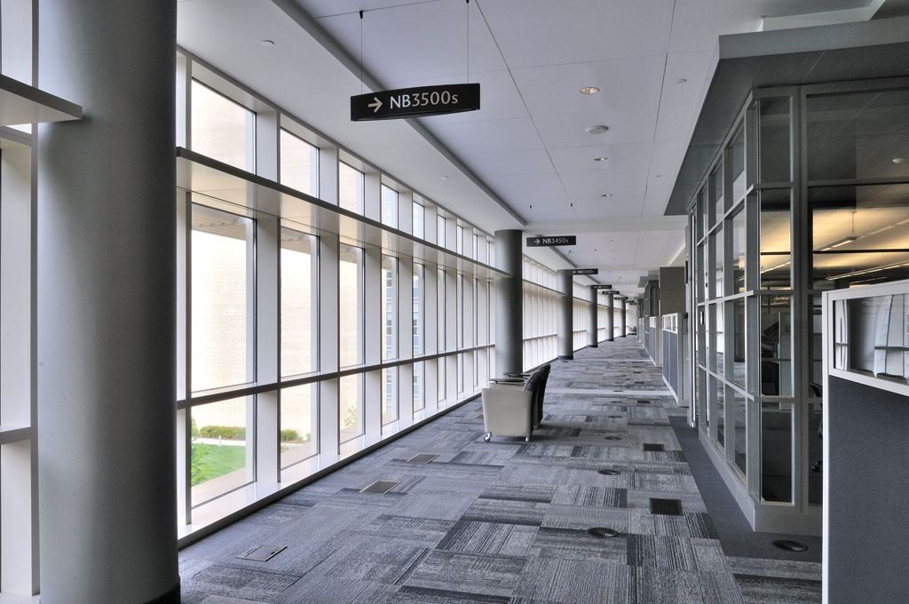 Lowe's: Long glazed corridor with grey carpet and a hanging directional sign