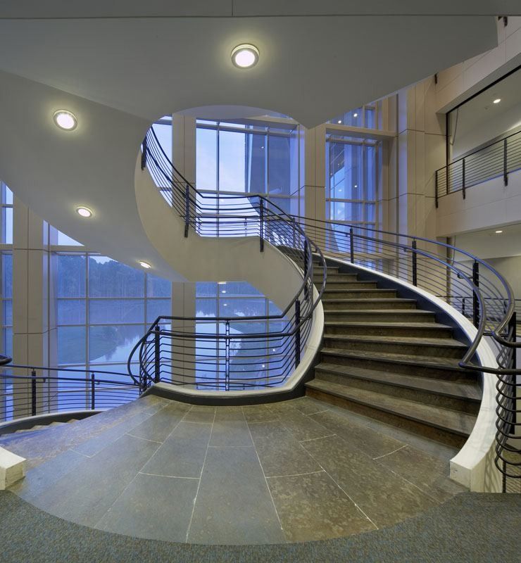 Lowe's: Sweeping spiral staircase in a round stair hall with tall windows
