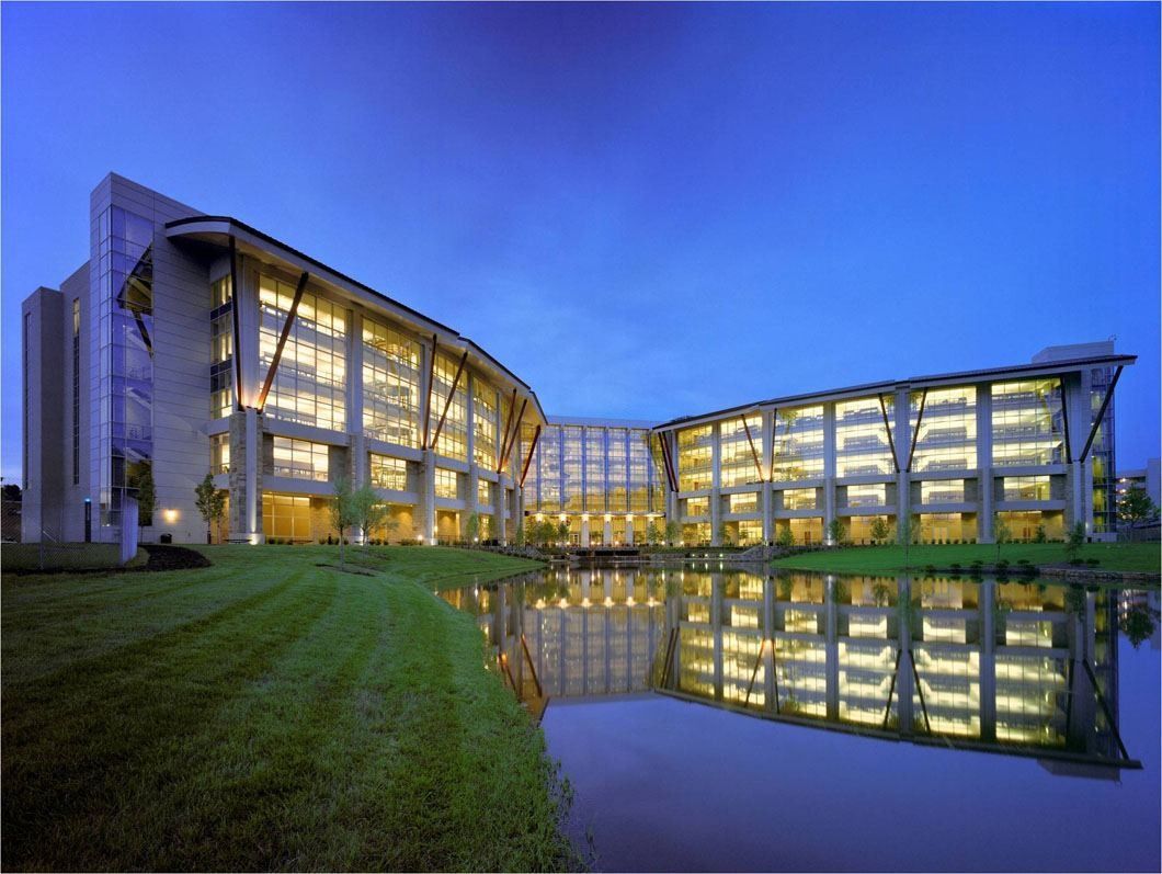 Lowe's: Two curving office wings with lit windows reflected in still water at twilight