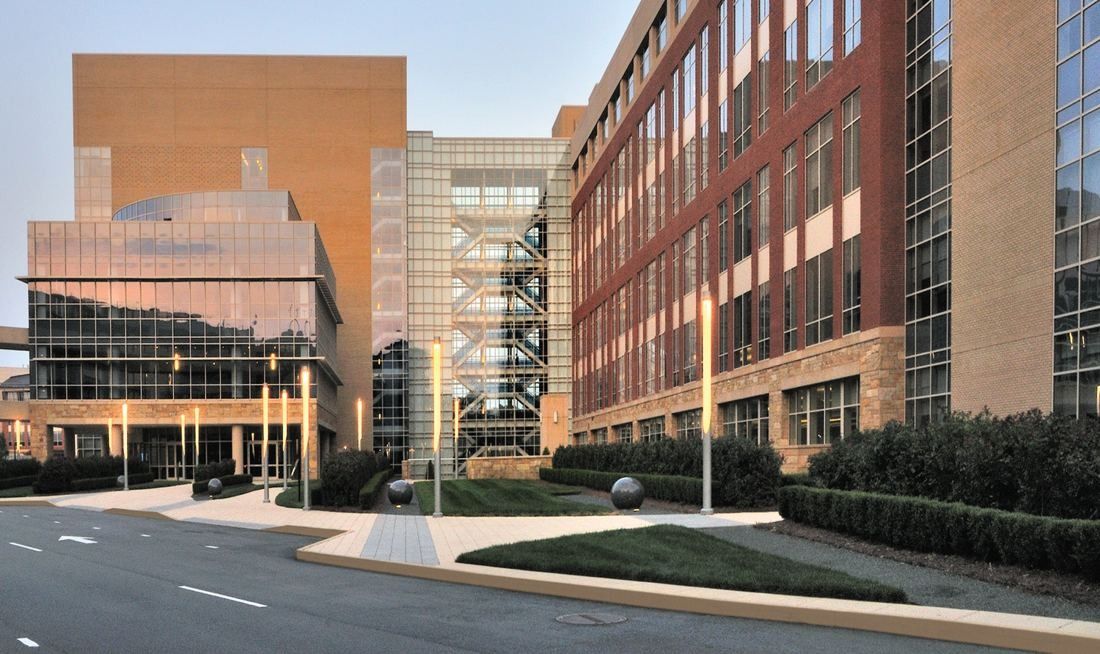 Lowe's: Two tall office towers in brick and glass facing a campus road and plaza