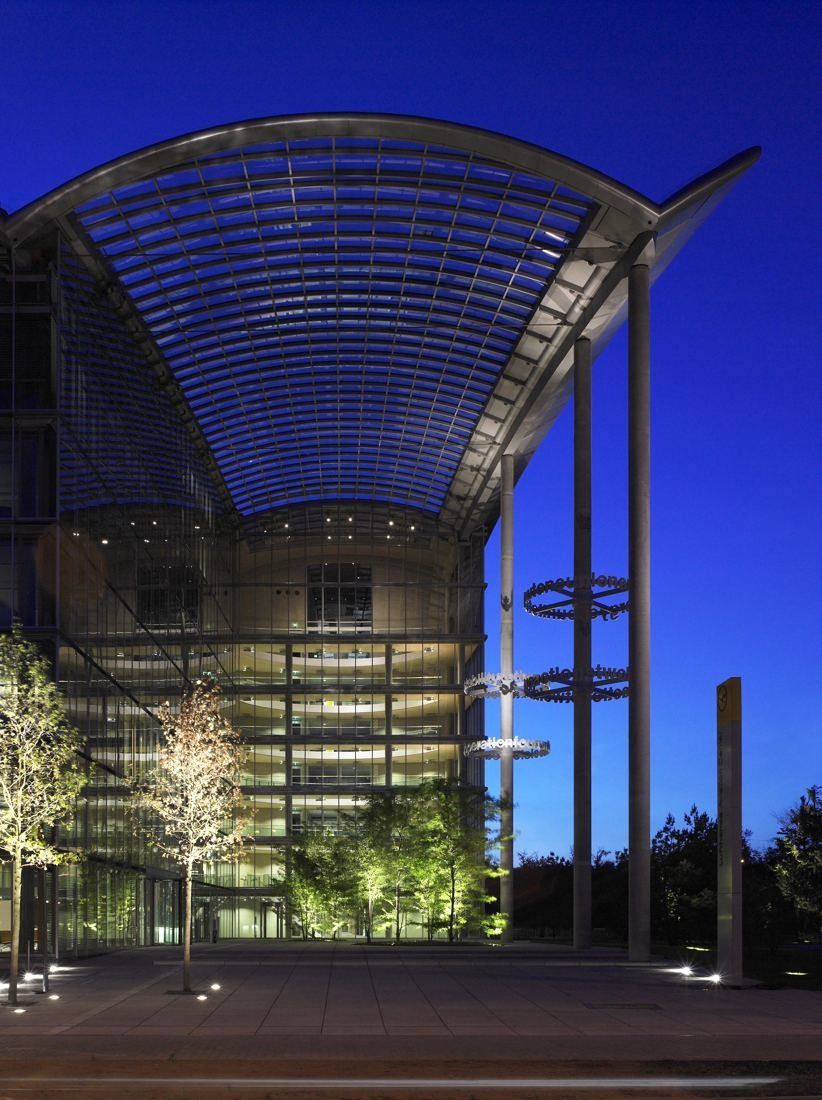 Lufthansa Group: Arched glass roof over a tall entrance hall lit at night