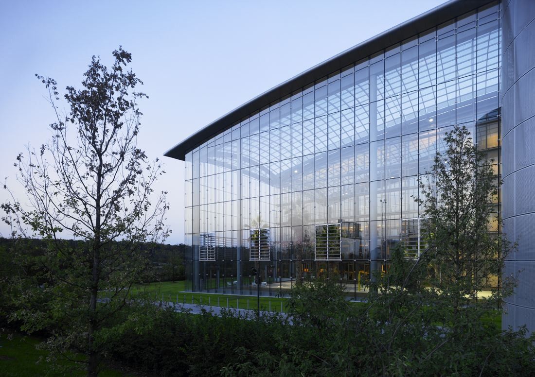 Lufthansa Group: Corner of a glass hall with trees in front at dusk