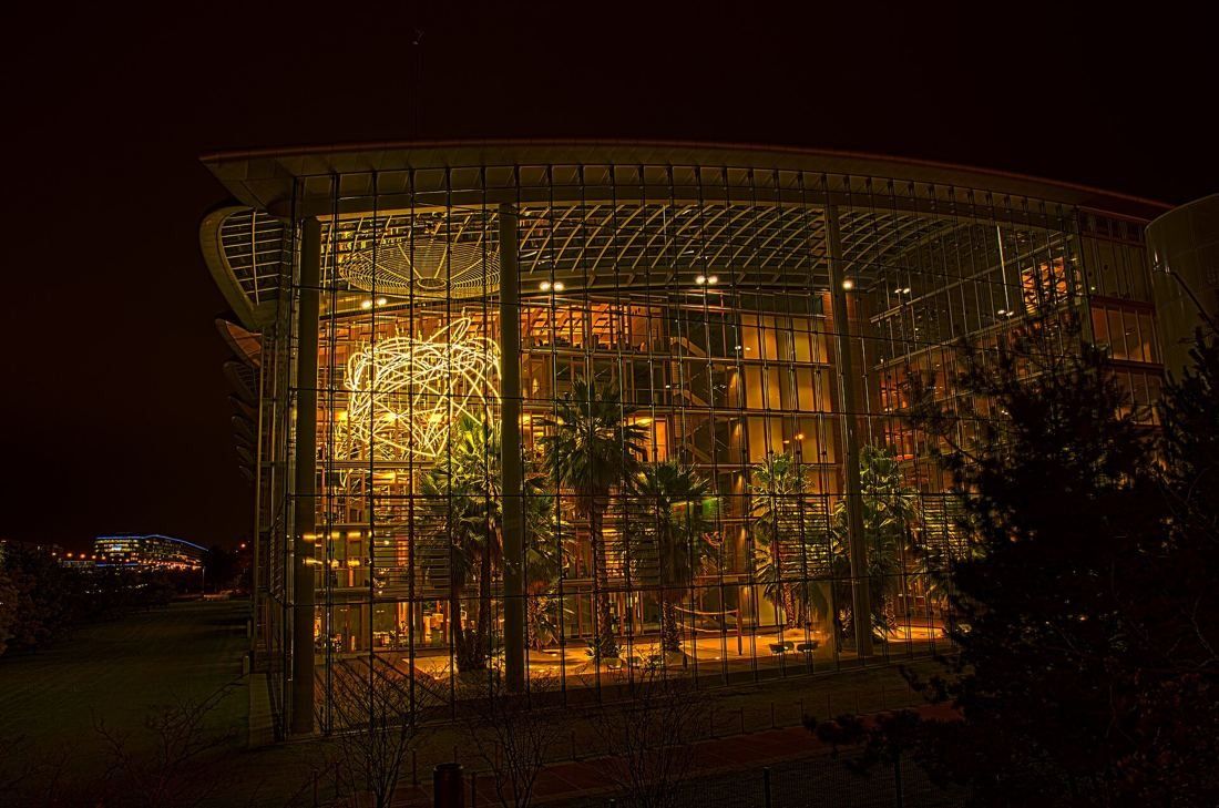 Lufthansa Group: Glass garden hall glowing warm at night with palm trees inside