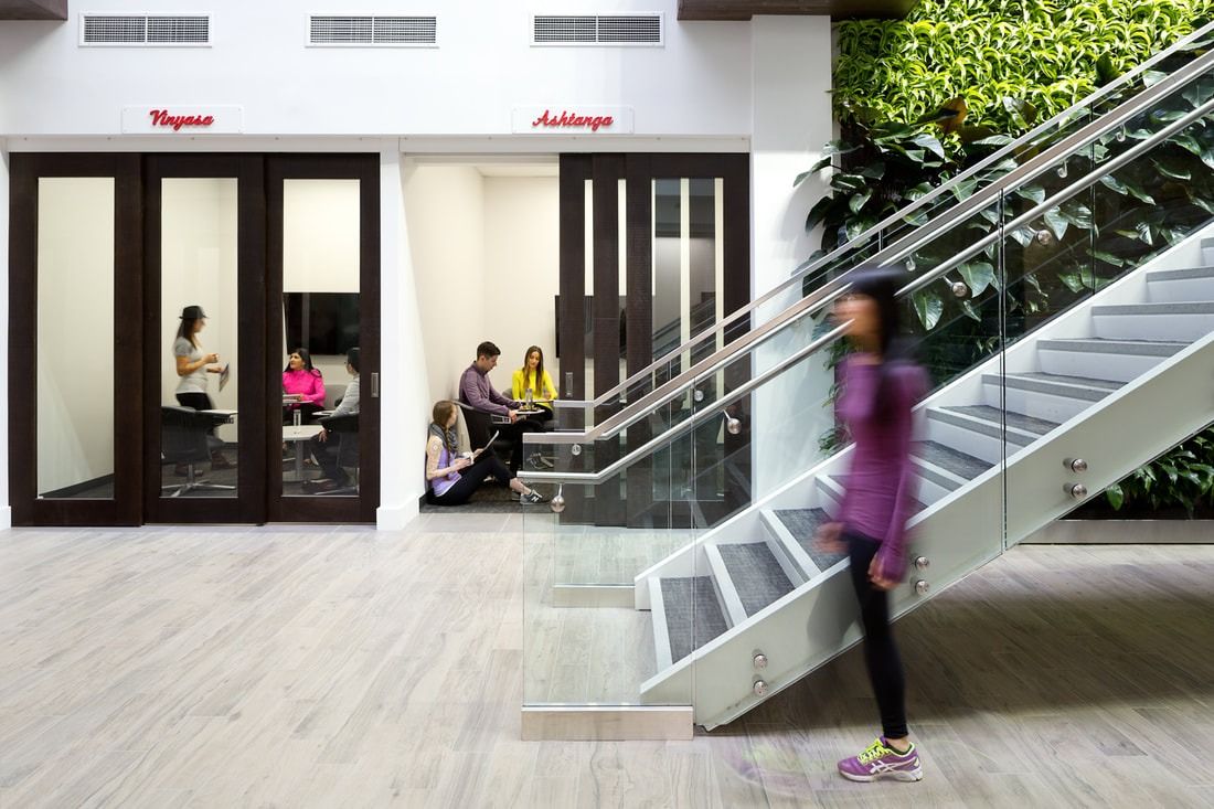 lululemon athletica: Glass-railed staircase beside a living wall and two meeting rooms