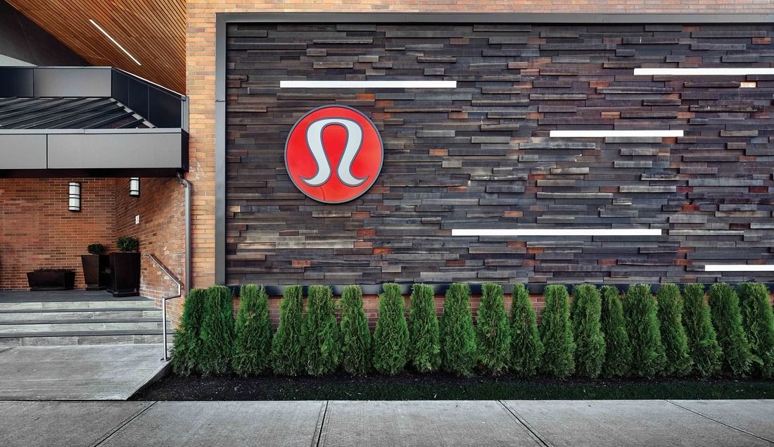 lululemon athletica: Stone wall with the lululemon logo above a row of shrubs