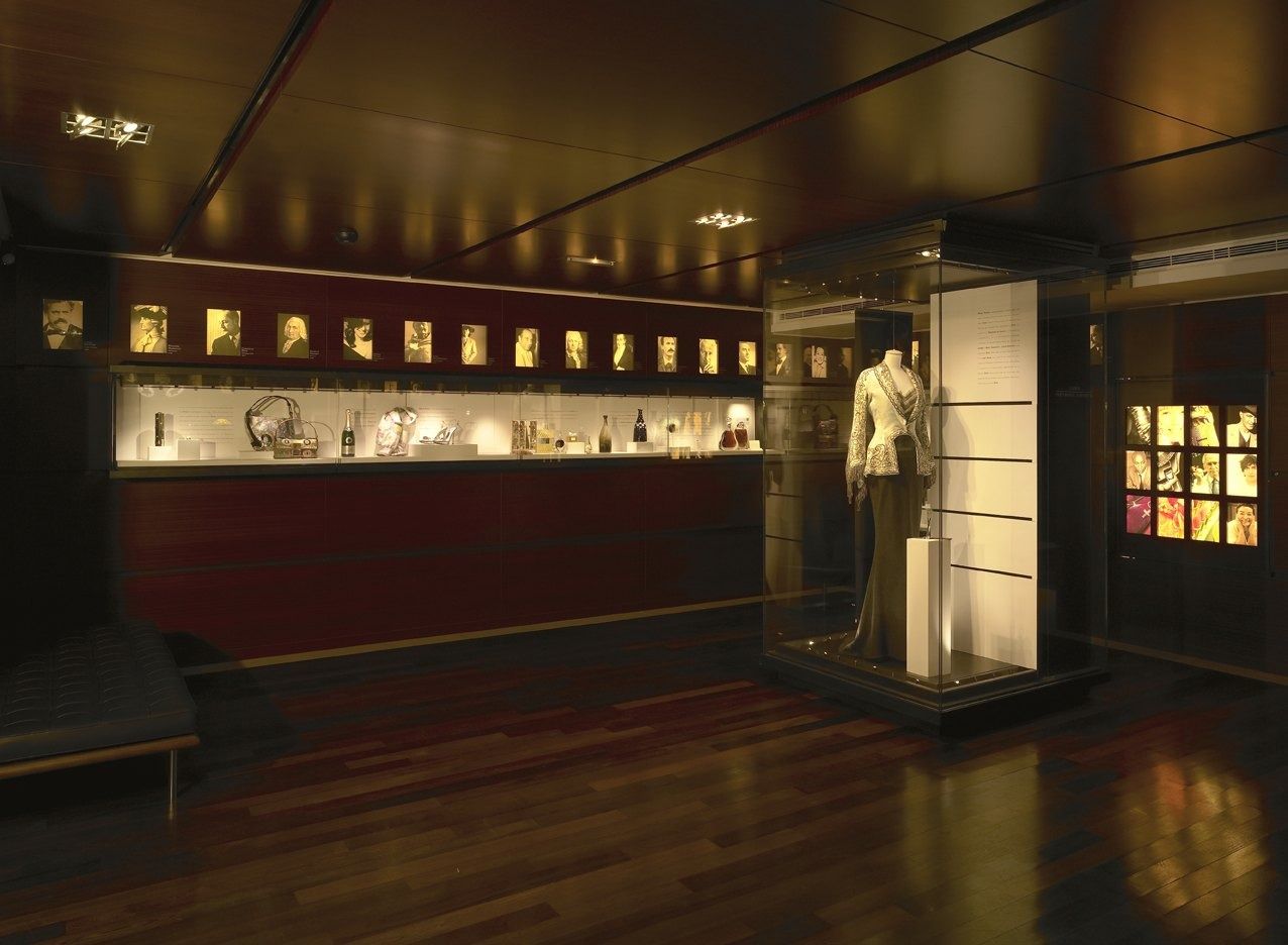 LVMH: A dark wood exhibition room with fashion displays