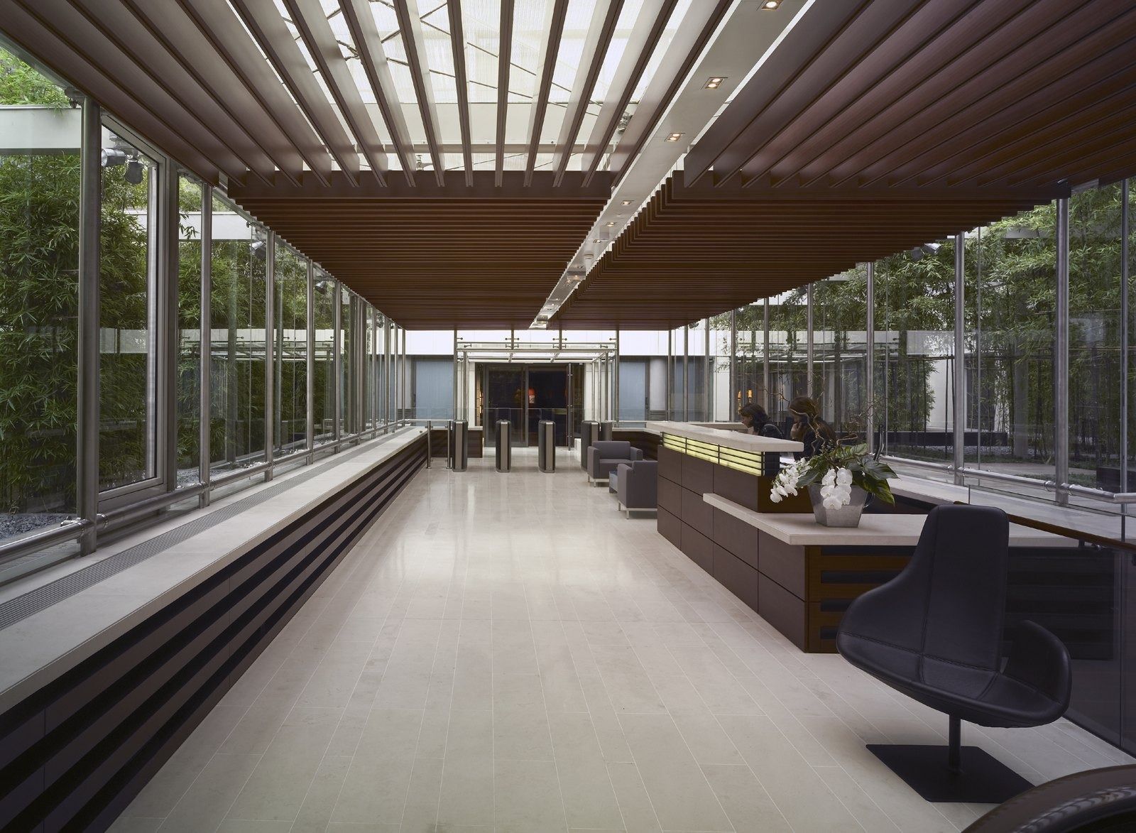 LVMH: A long glass gallery with sofas and timber louvres