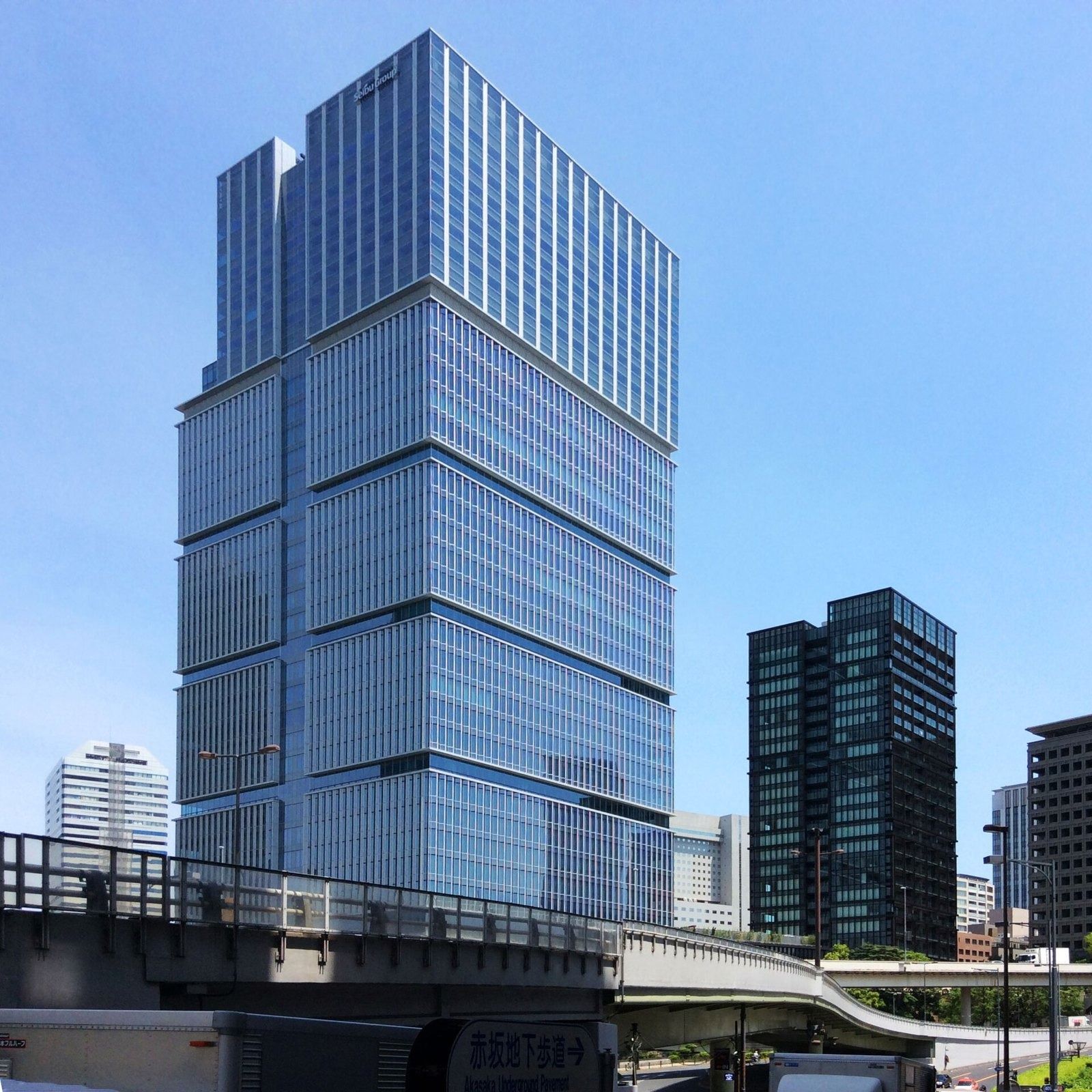 LY Corporation: Glass tower and a dark residential tower against a blue sky