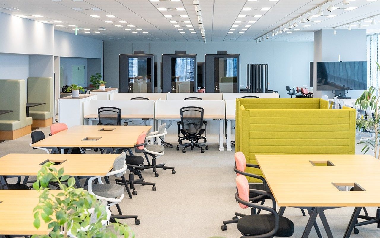 LY Corporation: Office floor with long tables, chairs and booths by windows