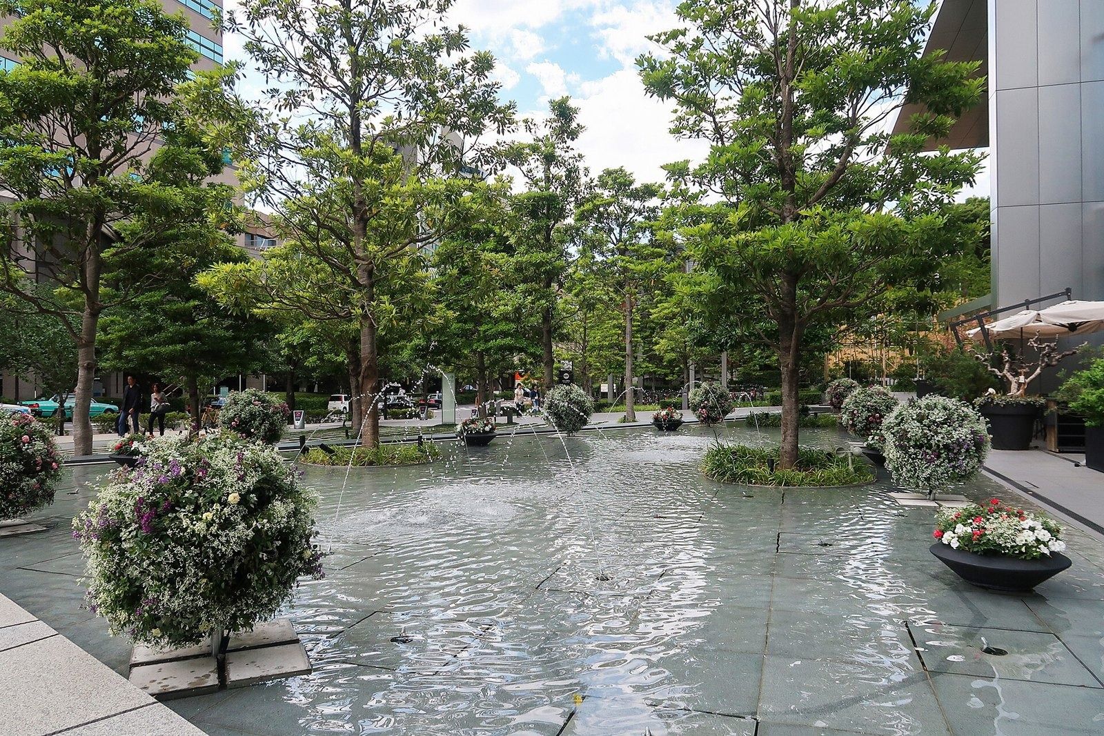 LY Corporation: Shallow fountain pool with planted islands among trees