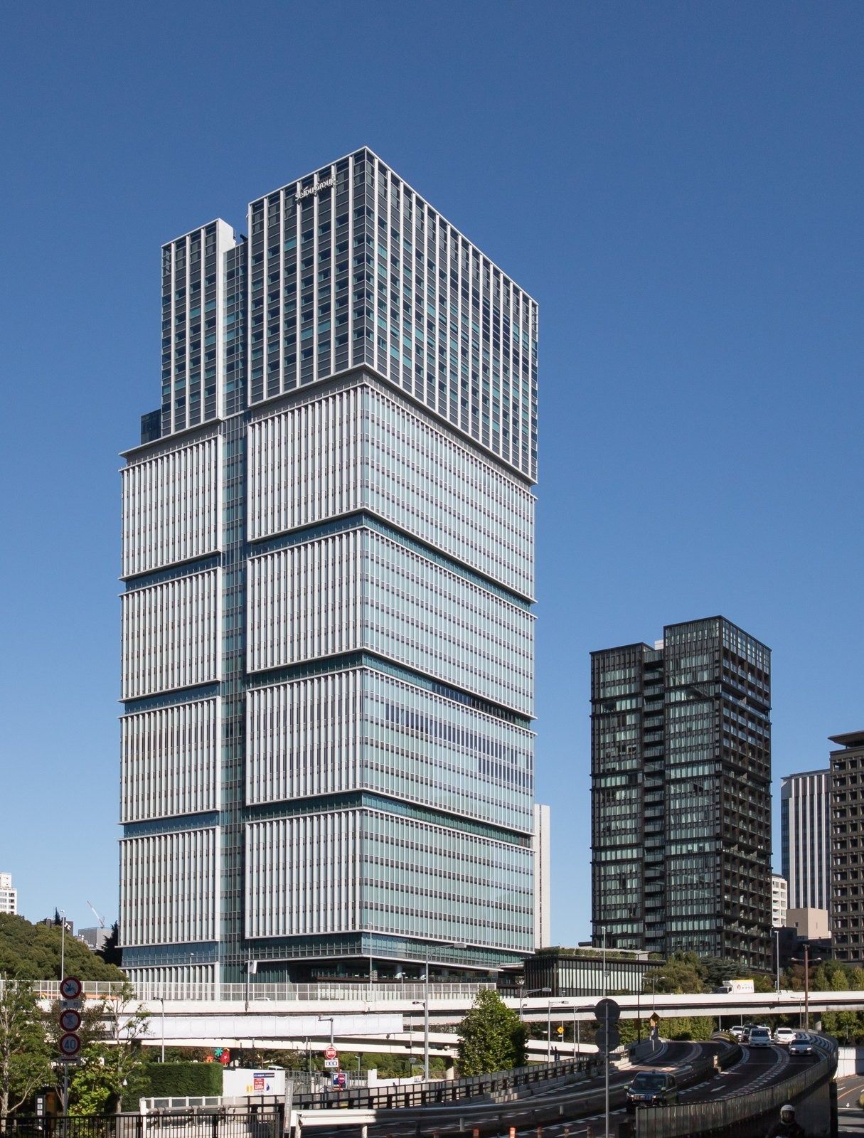 LY Corporation: Tower with stacked glass blocks seen across an elevated road