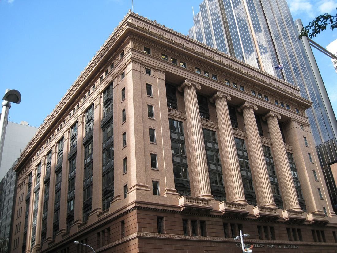 Macquarie Group: Colonnaded sandstone bank building with a glass tower behind
