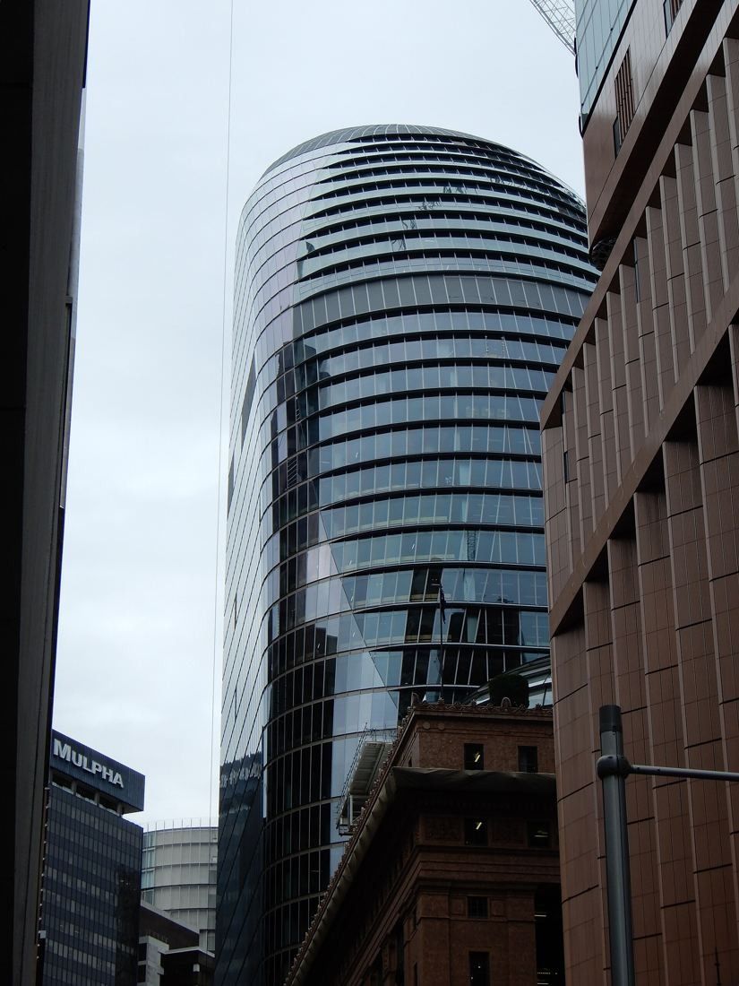 Macquarie Group: Curved glass tower seen between neighbouring buildings