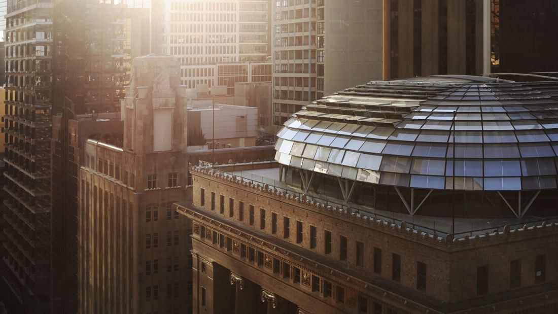 Macquarie Group: Glass dome on the roof of a sandstone bank building, lit by low sun