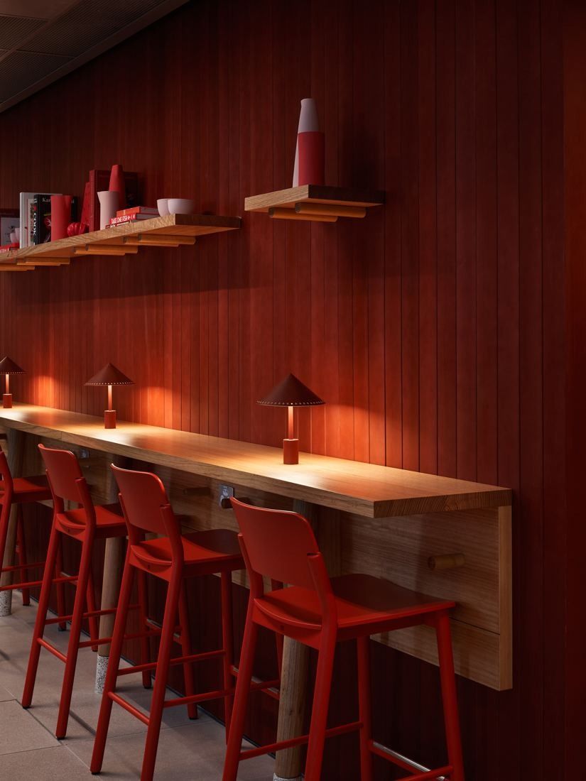 Macquarie Group: Red timber wall with a long counter and red stools