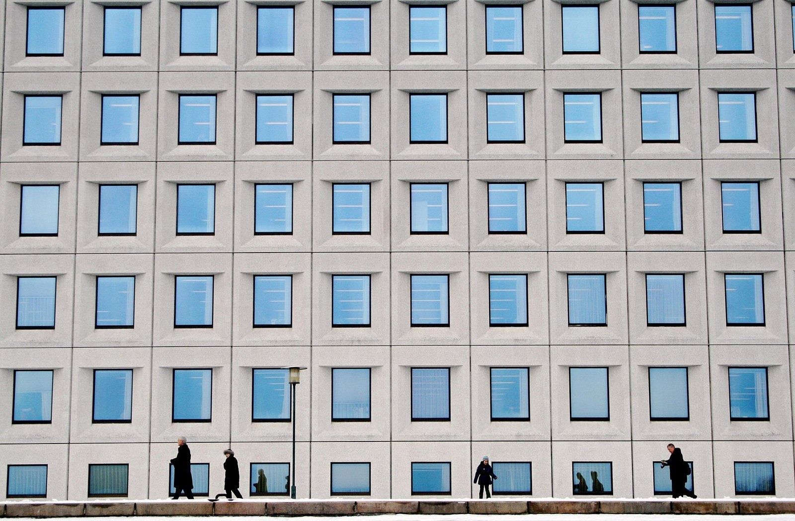 A.P. Moller - Maersk: Close view of the window grid with small silhouetted walkers along the quay